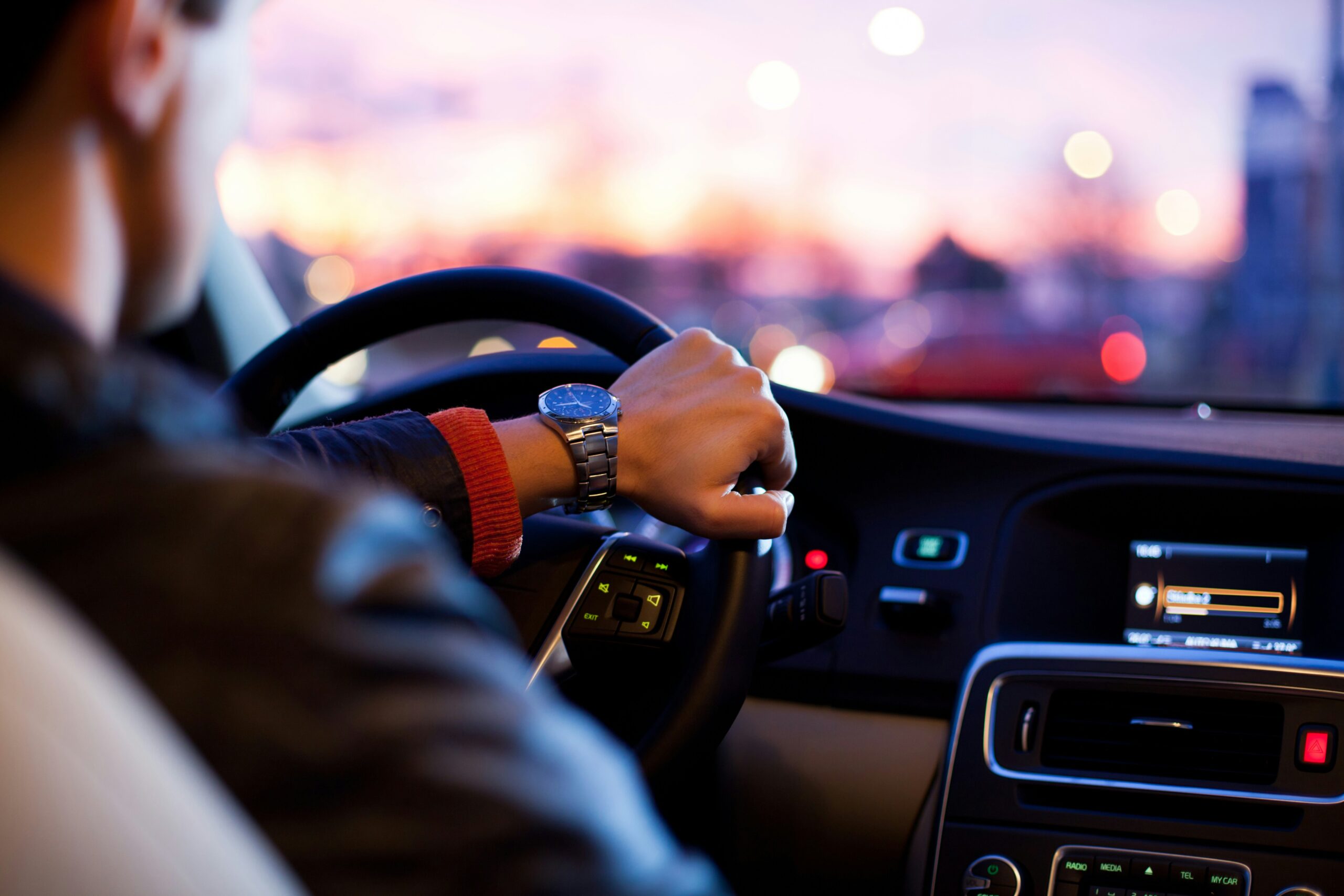 Ein Mann fährt bei Sonnenuntergang und nutzt GPS Ortung auf dem Bildschirm für präzise Fahrzeugortung.